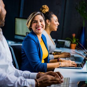 Photo: Woman in workforce smiling at office coworkers.